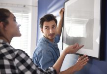 Tijd om de klusjes in de woonkamer aan te pakken! stel dat samen fotolijst ophangt