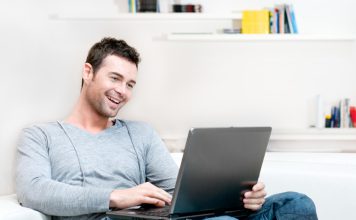 Online kansspelen doen na het klussen man ontspannen op de bank